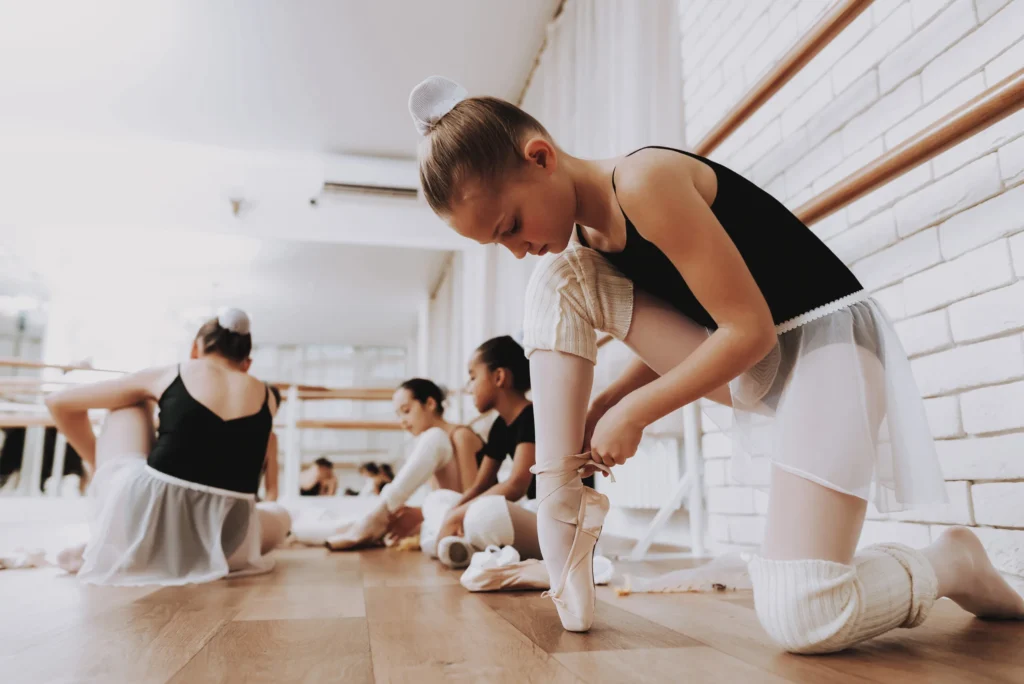 Jeunes filles se préparant à un cours de ballet en intérieur. Ballet classique. Fille en tutu de ballerine. Entraînement en salle. Jeunes danseuses mignonnes. Spectacle en salle. Séance d'entraînement. Filles en robes blanches.

